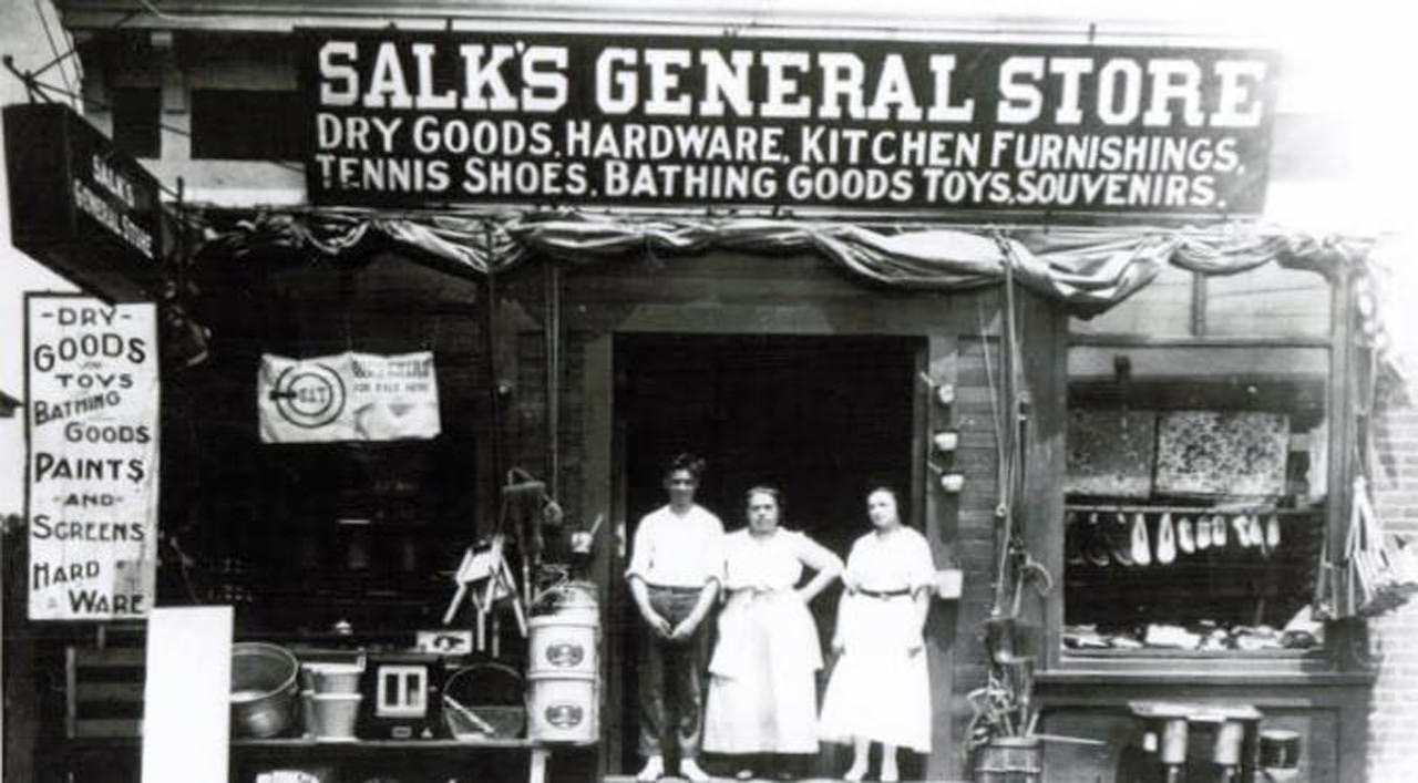 a dated image of three people standing in front of Salk's General Store